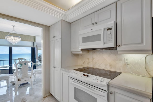 kitchen with white appliances, white cabinets, and a water view