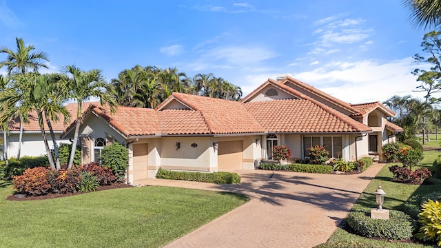 mediterranean / spanish home featuring a garage and a front lawn