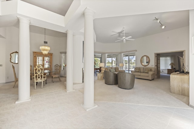 living room featuring french doors, ceiling fan with notable chandelier, ornate columns, and light tile patterned flooring