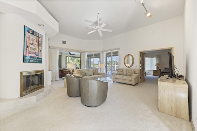 carpeted living room with track lighting and ceiling fan