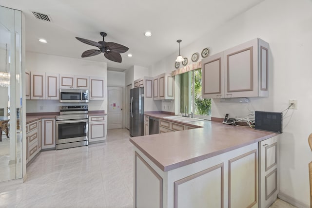 kitchen with sink, ceiling fan, appliances with stainless steel finishes, decorative light fixtures, and kitchen peninsula