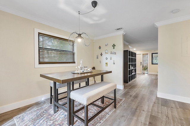 dining room with hardwood / wood-style floors and ornamental molding