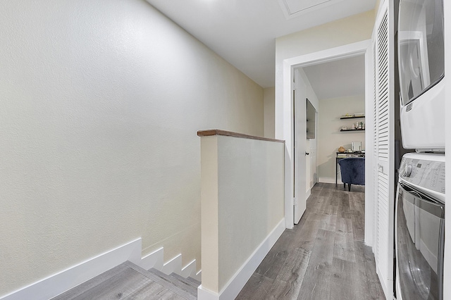 hall featuring light wood-type flooring and stacked washing maching and dryer