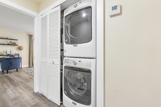 washroom featuring light hardwood / wood-style floors and stacked washing maching and dryer