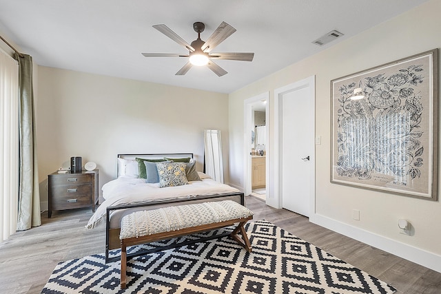 bedroom with connected bathroom, ceiling fan, and light hardwood / wood-style floors