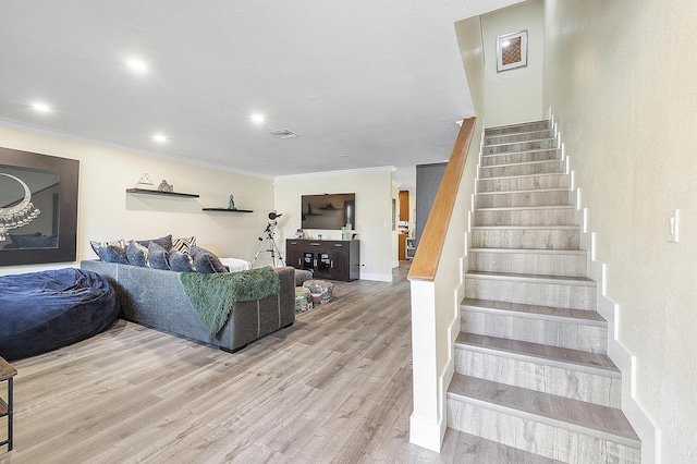 stairway featuring hardwood / wood-style floors and crown molding