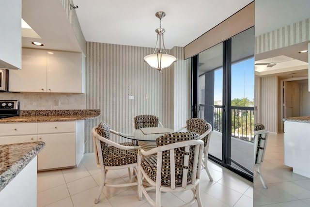 dining space with floor to ceiling windows and light tile patterned floors