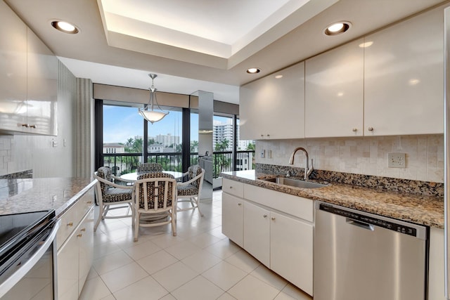 kitchen with appliances with stainless steel finishes, decorative light fixtures, stone countertops, white cabinets, and sink