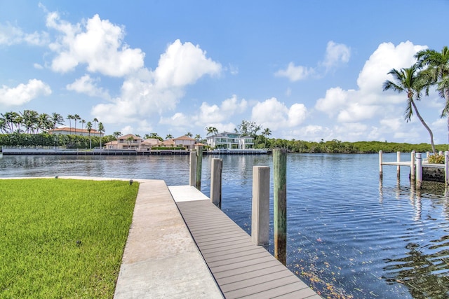 view of dock with a yard and a water view