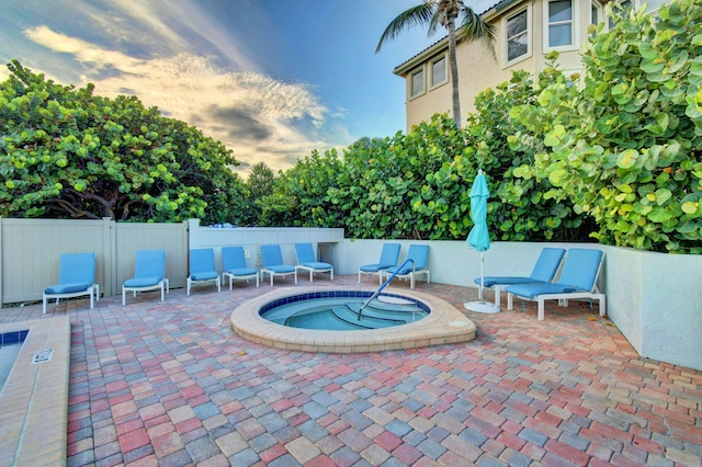 view of pool with a hot tub and a patio area