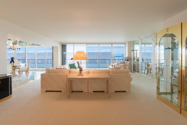 carpeted living room featuring an inviting chandelier, expansive windows, and a water view