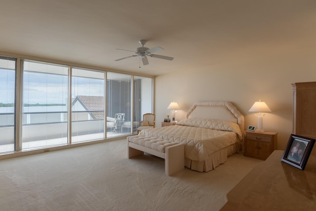 carpeted bedroom featuring ceiling fan, multiple windows, expansive windows, and access to exterior