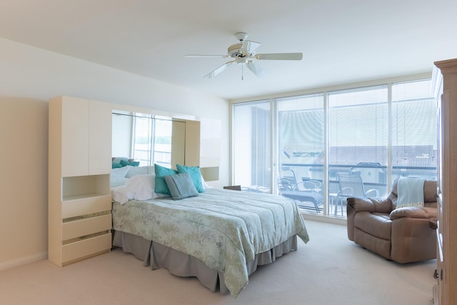 bedroom with access to outside, light colored carpet, ceiling fan, and expansive windows