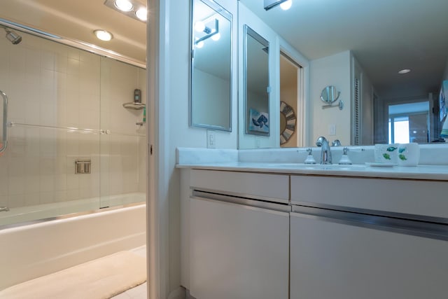 bathroom featuring shower / bath combination with glass door and vanity