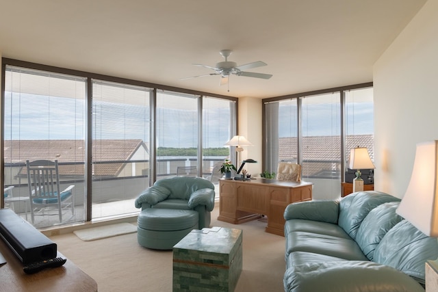 carpeted living room featuring ceiling fan, expansive windows, and a water view