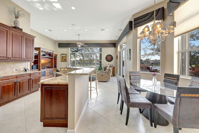 kitchen featuring open floor plan, tasteful backsplash, light tile patterned flooring, and pendant lighting