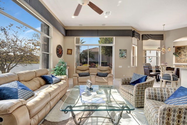 living room featuring ceiling fan with notable chandelier and a healthy amount of sunlight