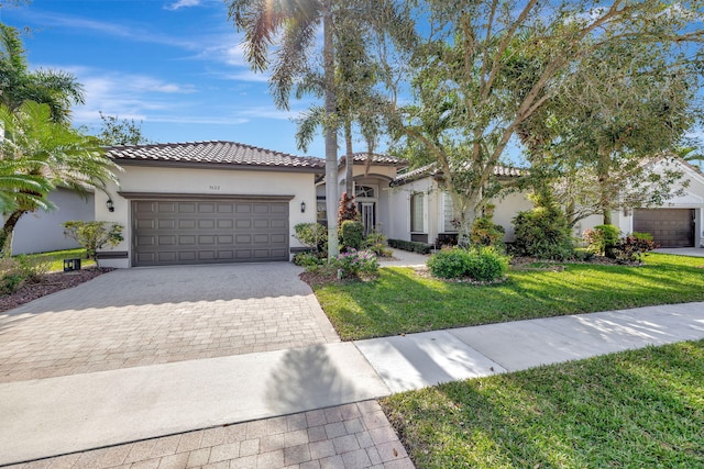 mediterranean / spanish-style home featuring a garage and a front yard