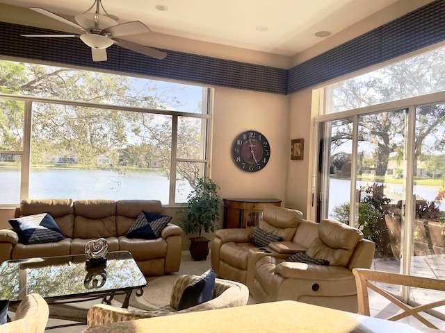 sunroom featuring a water view and ceiling fan