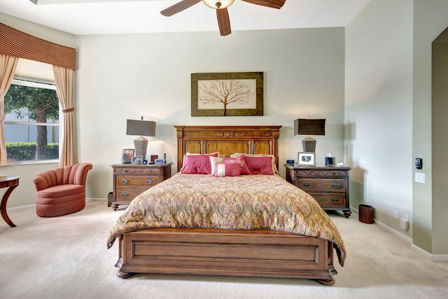 bedroom featuring light colored carpet, ceiling fan, and baseboards