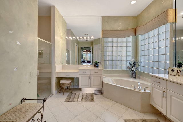 bathroom featuring a stall shower, tile patterned flooring, vanity, and a bath