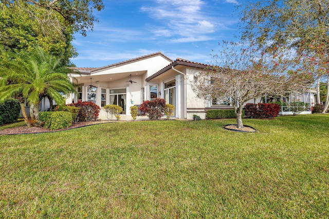 mediterranean / spanish-style house with a tile roof, a front lawn, and stucco siding