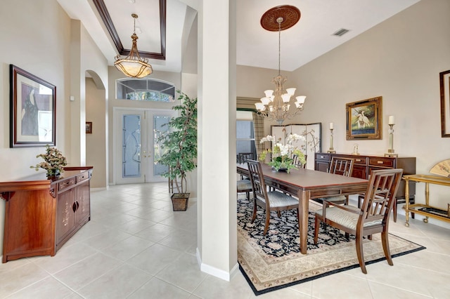 dining space with visible vents, a high ceiling, arched walkways, and light tile patterned flooring