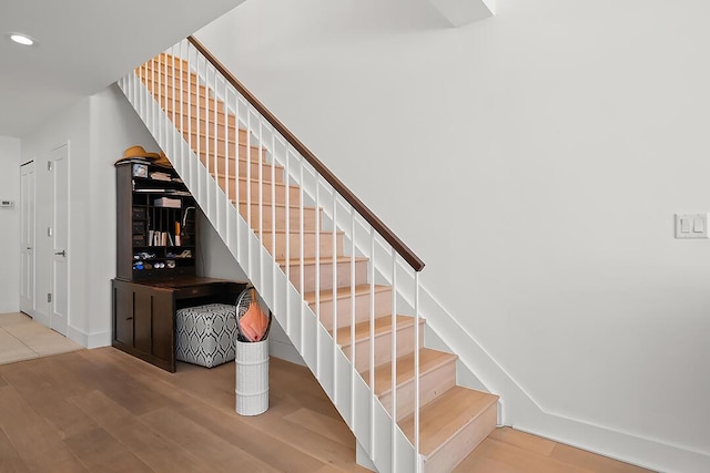 staircase with hardwood / wood-style flooring