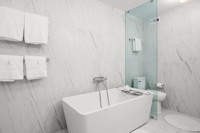 bathroom with a washtub and toilet