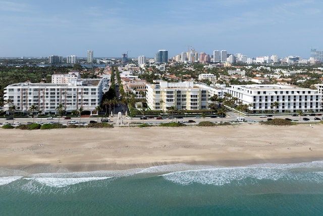 birds eye view of property with a water view and a beach view