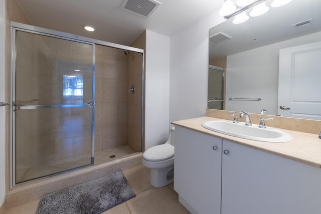 bathroom with toilet, vanity, tile patterned floors, and a shower with shower door