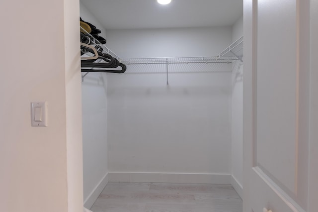 walk in closet with light wood-type flooring