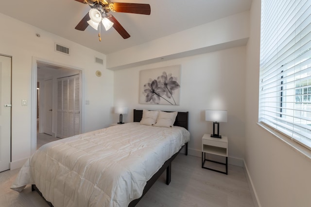 bedroom with light wood-type flooring, a closet, and ceiling fan