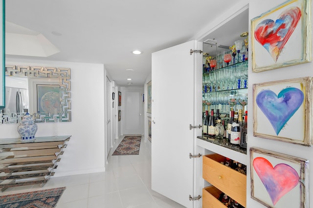 bar featuring stainless steel fridge and light tile patterned floors