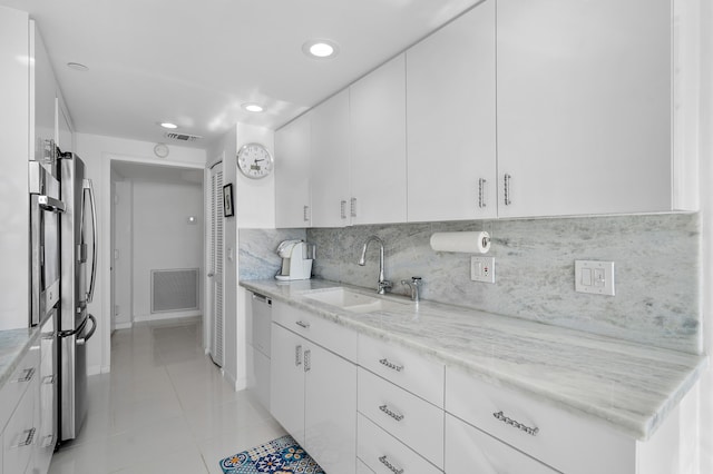 kitchen with white cabinets, appliances with stainless steel finishes, light tile patterned floors, and sink