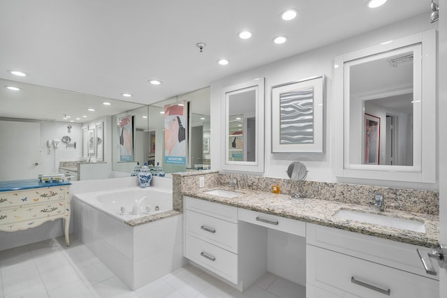 bathroom featuring tile patterned flooring, vanity, and a relaxing tiled tub