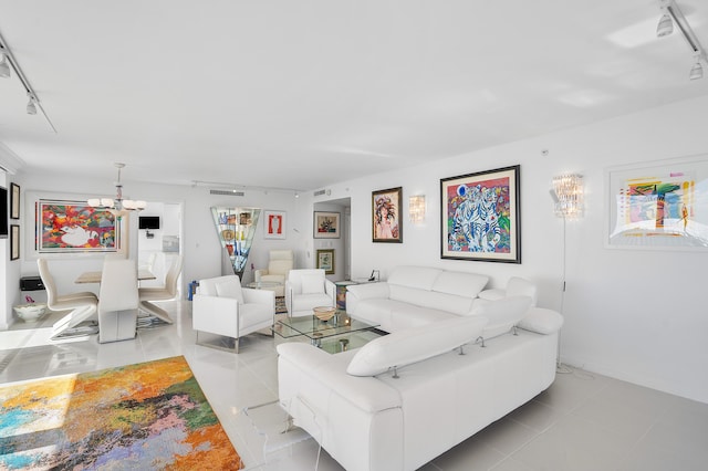 tiled living room with rail lighting and a notable chandelier