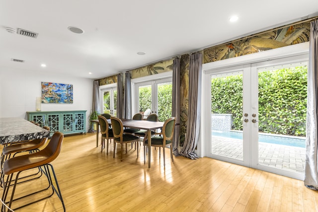 dining room with french doors, a healthy amount of sunlight, and light wood-type flooring