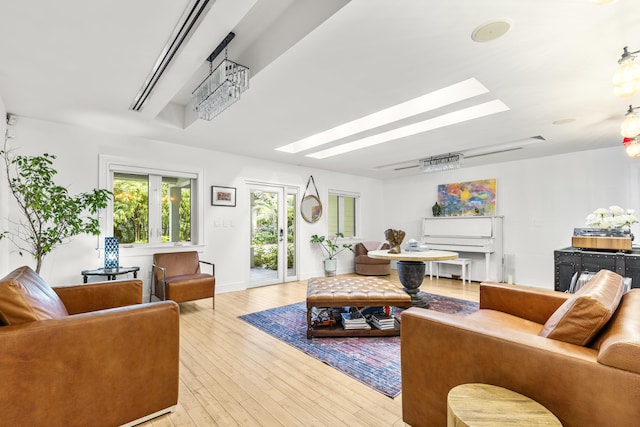 living room featuring a skylight and light hardwood / wood-style flooring