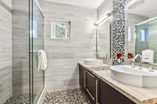 bathroom with vanity, tile walls, and walk in shower