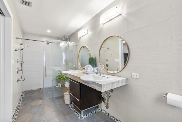 bathroom featuring vanity, a shower with shower door, and tile walls