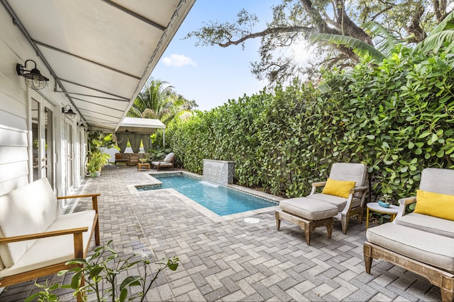 view of pool featuring a patio area, an outdoor living space, and pool water feature