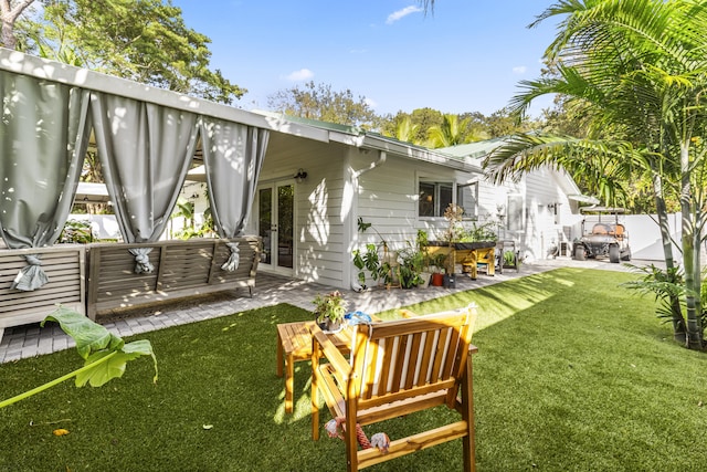 rear view of property featuring french doors, an outdoor hangout area, a patio, and a lawn