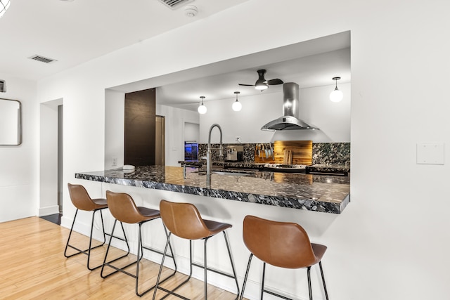 kitchen featuring island exhaust hood, decorative backsplash, sink, and hanging light fixtures