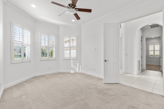 empty room with ceiling fan, ornamental molding, and light carpet