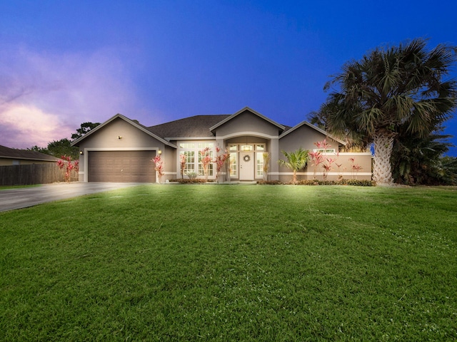 ranch-style home featuring a yard and a garage