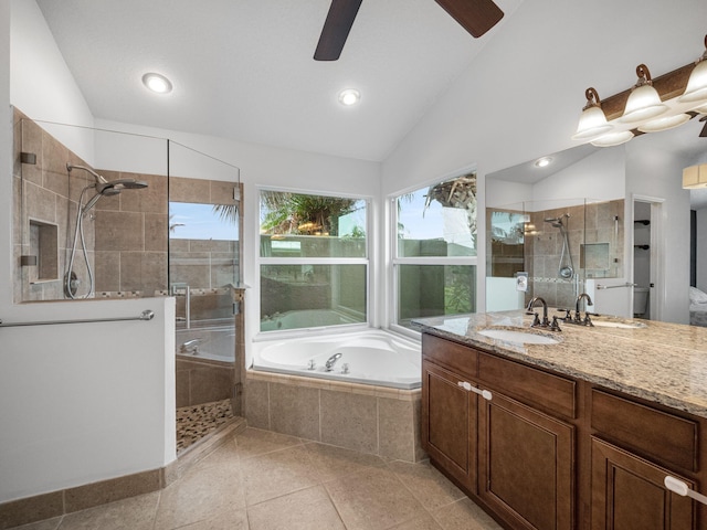 bathroom with tile patterned flooring, shower with separate bathtub, vaulted ceiling, and vanity