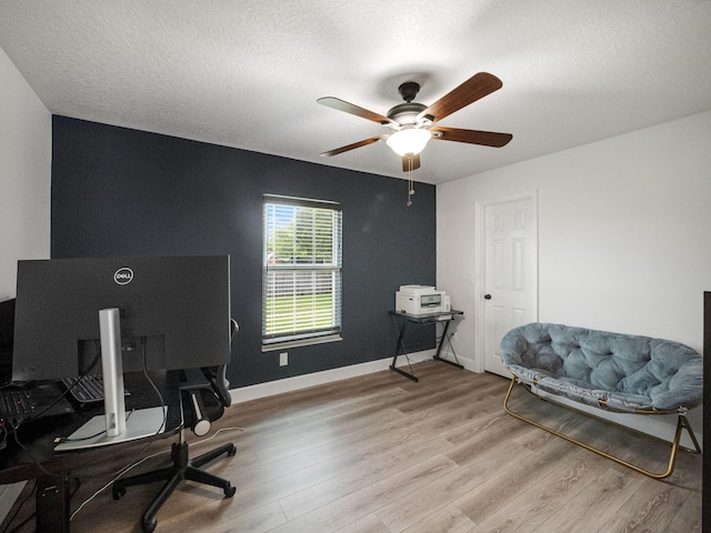 office with a textured ceiling, light wood-type flooring, and ceiling fan