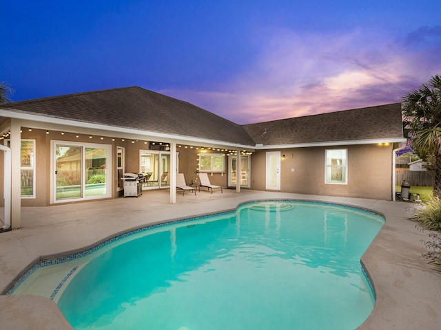 pool at dusk with a patio