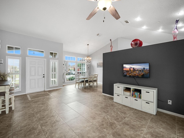 living room featuring ceiling fan with notable chandelier and vaulted ceiling